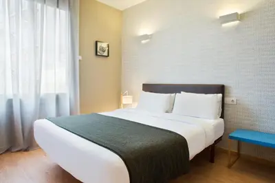 a bedroom with a large white bed and a window at Bonavista Apartments - Pedrera in Barcelona