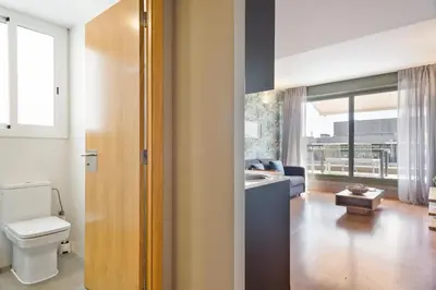 a bathroom with a toilet and a living room at Bonavista Apartments - Pedrera in Barcelona