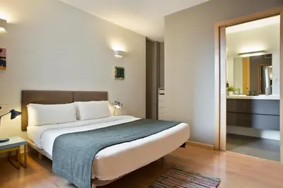 a bedroom with a large bed and a bathroom at Bonavista Apartments - Pedrera in Barcelona