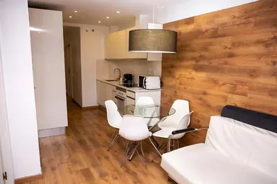 a living room with a table and white chairs at DragonTree Barcelona - apartamentos turisticos 5 min from the BEACH in Barcelona