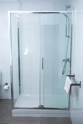 a shower with a glass door in a bathroom at DragonTree Barcelona - apartamentos turisticos 5 min from the BEACH in Barcelona