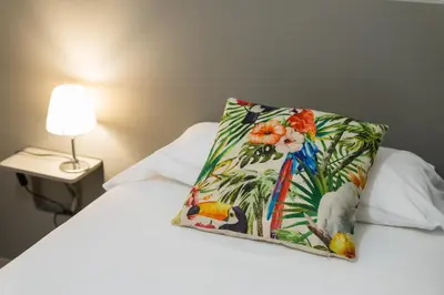 a pillow on top of a bed with a lamp at Apartamento Manent in Premiá de Mar