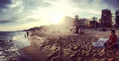 a group of people sitting on the beach at Apartamento Manent in Premiá de Mar