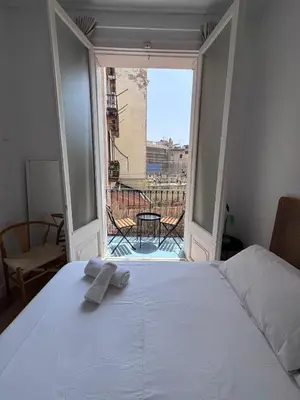 a bedroom with a white bed and a large window at Calma House Barcelona in Barcelona