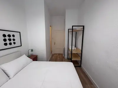 a bedroom with a white bed and a mirror at Calma House Barcelona in Barcelona