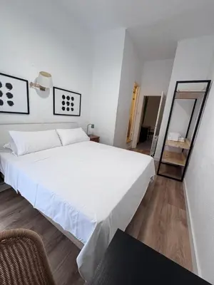 a bedroom with a large white bed and a mirror at Calma House Barcelona in Barcelona