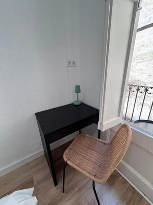 a desk with a lamp and a chair in a room at Calma House Barcelona in Barcelona
