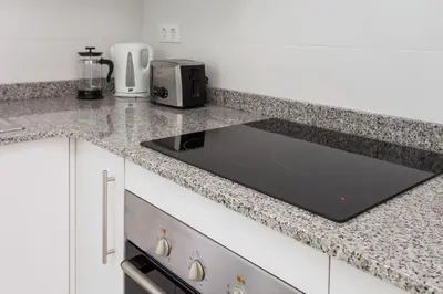 a kitchen with a counter top with a sink at Contemporary Apartment Near Camp Nou and Fira Barcelona in Hospitalet de Llobregat