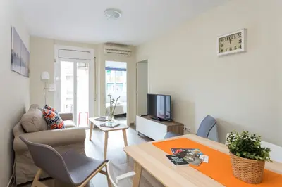 a living room with a couch and a tv at Contemporary Apartment Near Camp Nou and Fira Barcelona in Hospitalet de Llobregat
