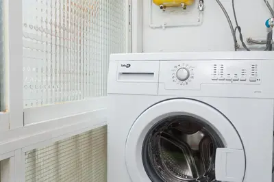 a white washing machine in a white laundry room at Contemporary Apartment Near Camp Nou and Fira Barcelona in Hospitalet de Llobregat