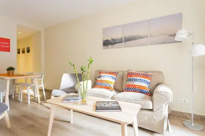 a living room with a couch and a table at Contemporary Apartment Near Camp Nou and Fira Barcelona in Hospitalet de Llobregat