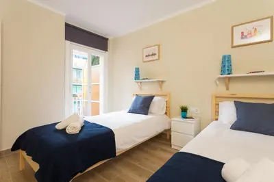 a bedroom with two beds and a window at Contemporary Apartment Near Camp Nou and Fira Barcelona in Hospitalet de Llobregat