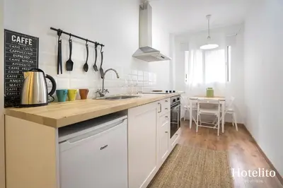 a kitchen with white cabinets and a counter top at Hotelito Boutique Camp Nou in Hospitalet de Llobregat