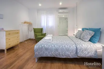 a bedroom with a bed and a desk and a chair at Hotelito Boutique Camp Nou in Hospitalet de Llobregat