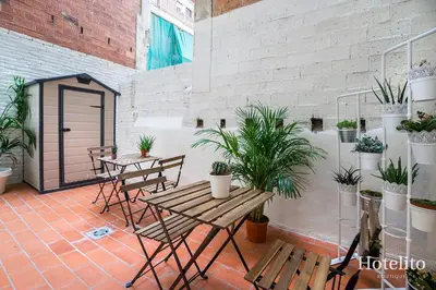 a patio with tables and chairs and potted plants at Hotelito Boutique Camp Nou in Hospitalet de Llobregat