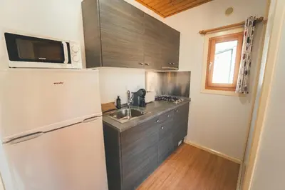 a small kitchen with a sink and a refrigerator at HolaCamp Sitges Relax in Sitges