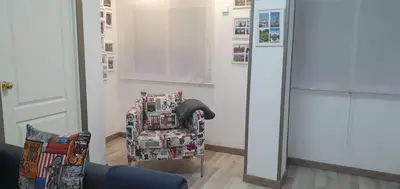 a chair sitting in a room with a mirror at APARTAMENTS B O D CoLLBLANC in Hospitalet de Llobregat