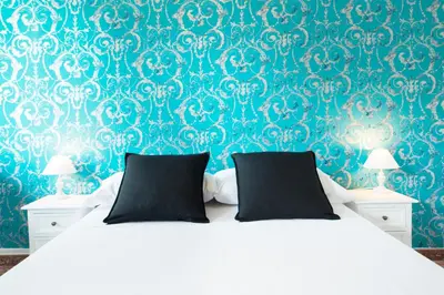 a bedroom with a white bed with a blue wall at Fira Guest House in Barcelona