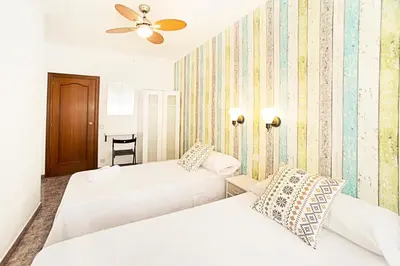 a bedroom with two beds and a ceiling fan at Fira Guest House in Barcelona