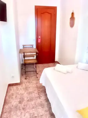 a room with two beds and a table and a red door at Fira Guest House in Barcelona