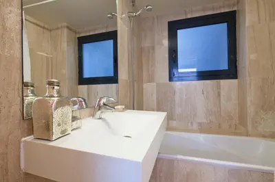 a bathroom with a white sink and a bath tub at Apartment Barcelona Rentals - Private Pool and Garden Center in Barcelona