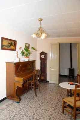 a living room with a piano and a table at Ca la Paula in Pla del Panadés