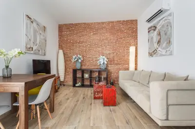 a living room with a white couch and a brick wall at Matarolux 7 in Mataró