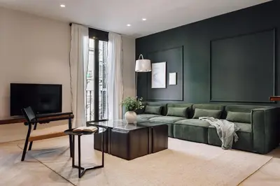 a living room with a green couch and a table at Lunalux Apartment in Barcelona
