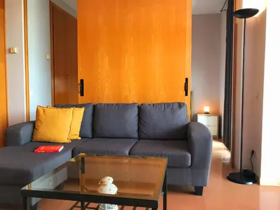 a living room with a blue couch and a table at Barceló Cornellà in Cornellà de Llobregat