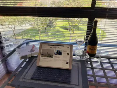 a laptop computer sitting on a table with a bottle of wine at Barceló Cornellà in Cornellà de Llobregat