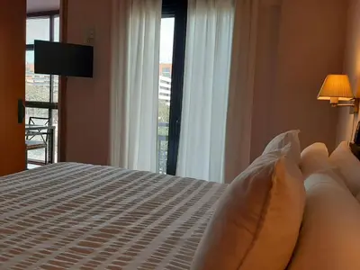 a bedroom with a bed and a large window at Barceló Cornellà in Cornellà de Llobregat