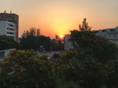 a sunset in a city with trees and buildings at Barceló Cornellà in Cornellà de Llobregat