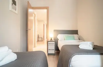 a small bedroom with two beds and a mirror at The Family Host - Lost Garden Ciutadella Park in Barcelona