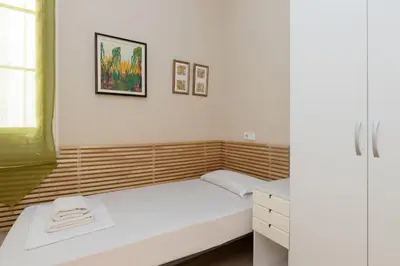 a small bedroom with a bed and a window at ApartEasy - Family 4-Bedroom Apartment in Barcelona