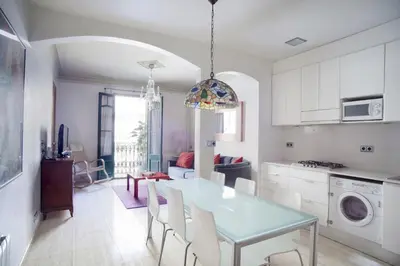 a kitchen and dining room with a table and chairs at ApartEasy - Authentic Family Apartment in Barcelona