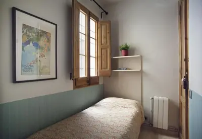 a room with a window and a bench in it at ApartEasy - Authentic Family Apartment in Barcelona