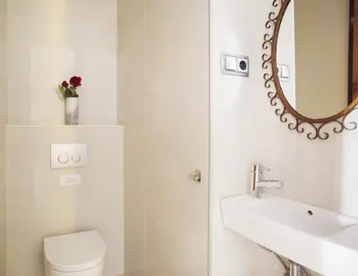 a bathroom with a sink and a mirror and a toilet at ApartEasy - Authentic Family Apartment in Barcelona