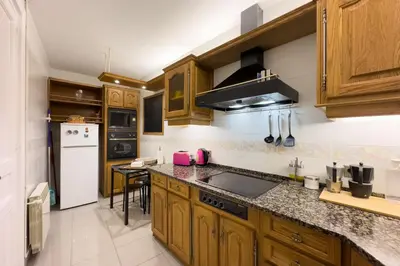 a kitchen with wooden cabinets and a counter top at ApartEasy - Passeig de Gracia in Barcelona