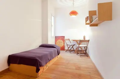 a bedroom with a bed and a table with chairs at ApartEasy - Atic Sagrada Familia in Barcelona