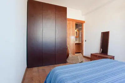 a bedroom with a bed and a wooden cabinet at ApartEasy - Atic Sagrada Familia in Barcelona