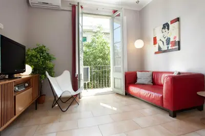 a living room with a red couch and a tv at ApartEasy - Family Sant Antoni apt. in Barcelona