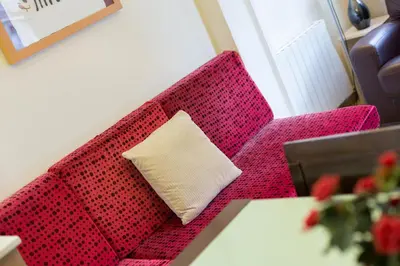 a red couch with a pillow in a living room at ApartEasy - Family Apartment Sant Antoni in Barcelona