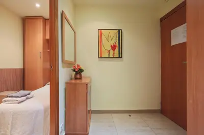 a bedroom with a bed and a table with flowers on it at ApartEasy - Family Apartment Sant Antoni in Barcelona