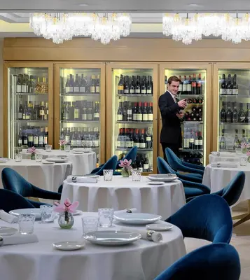a man standing in a room with tables and chairs at The One Barcelona GL in Barcelona