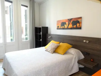 a bedroom with a large bed with yellow pillows at Feel at Sants Apartments in Barcelona