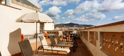 a balcony with chairs and an umbrella and a table at Feel at Sants Apartments in Barcelona