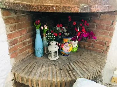 a brick fireplace with vases and flowers on a table at Heart of Gracia in Barcelona