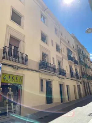 a tall white building with balconies on a street at Heart of Gracia in Barcelona