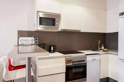 a kitchen with white cabinets and a microwave at Tendency Plaza España in Barcelona
