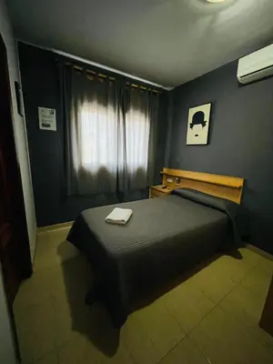 a bedroom with a bed and a window at Hostal del Carmen in Terrassa